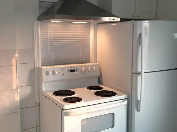 Small kitchen with oven and refrigerator renovated by David's Quality Renovations.